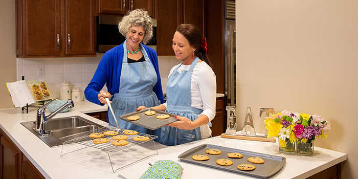 Memory care resident and Linden House Assisted Living team member bake cookies at The Gardens Memory Care