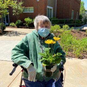 A resident holds her new flowers
