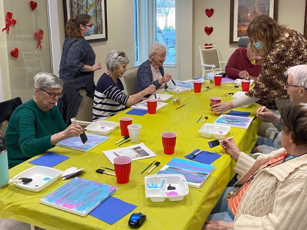 Assisted living residents doing paint and sip activity