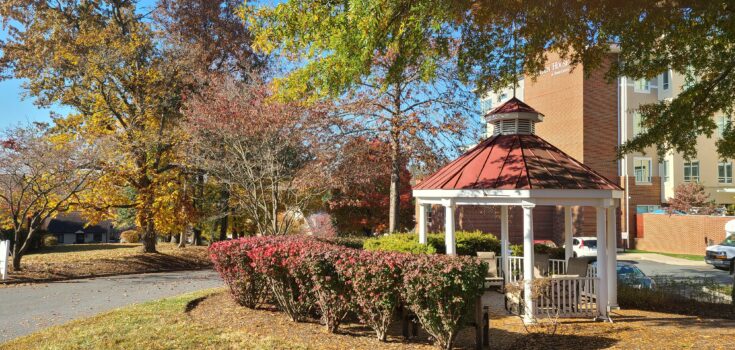 A gazebo surrounded by fall foliage, with Linden House Assisted Living in the background.