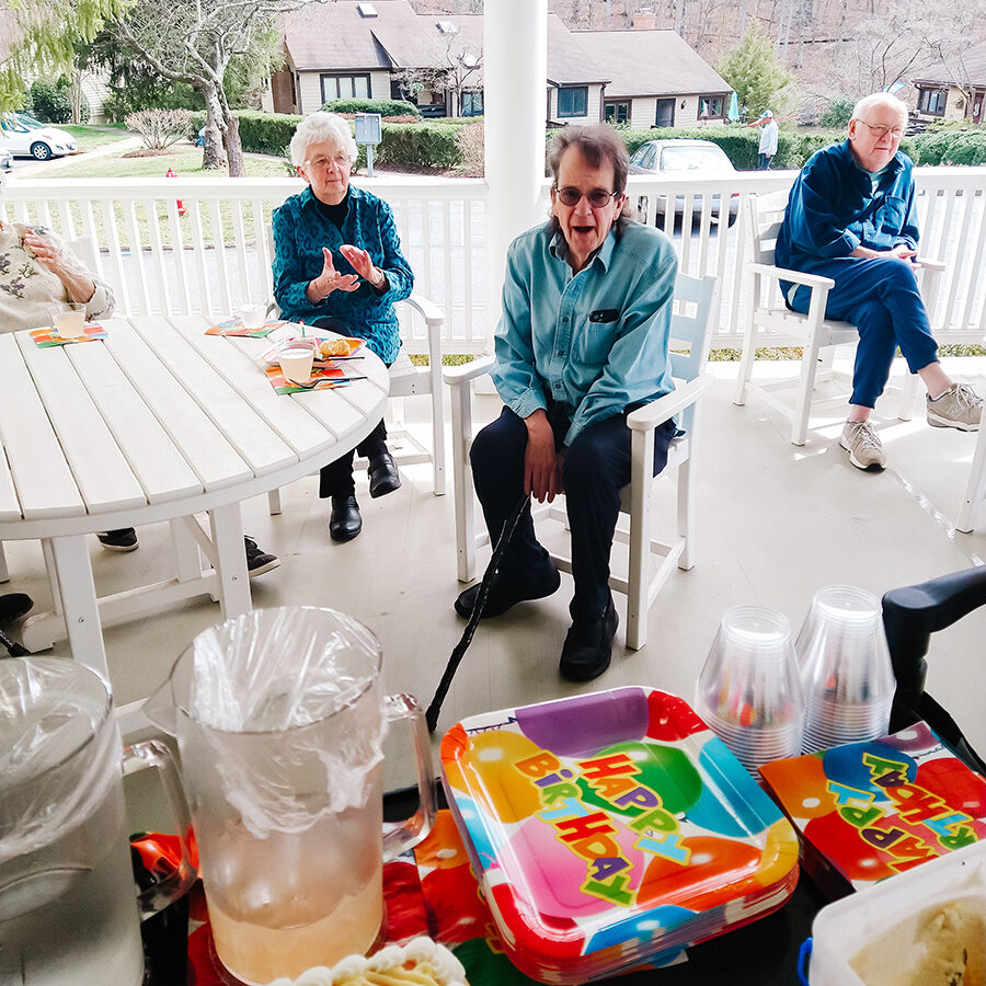 Senior Living residents celebrating a birthday on the Manor House porch