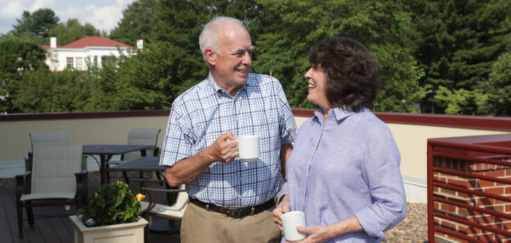 Two seniors enjoying coffee outside.